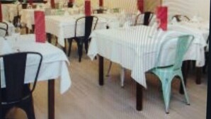 A restaurant with multiple tables and chairs, each covered with white tablecloths. - Hotel Andino (Encamp)