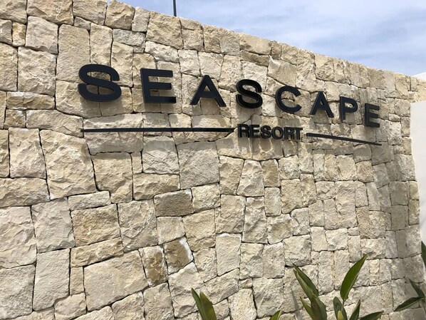Un muro di pietra con la scritta "SEASCAPE RESORT", che indica il nome della struttura.