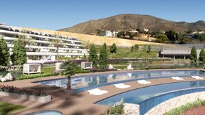A resort with a large pool, a mountain backdrop, and a multi-story building with balconies.