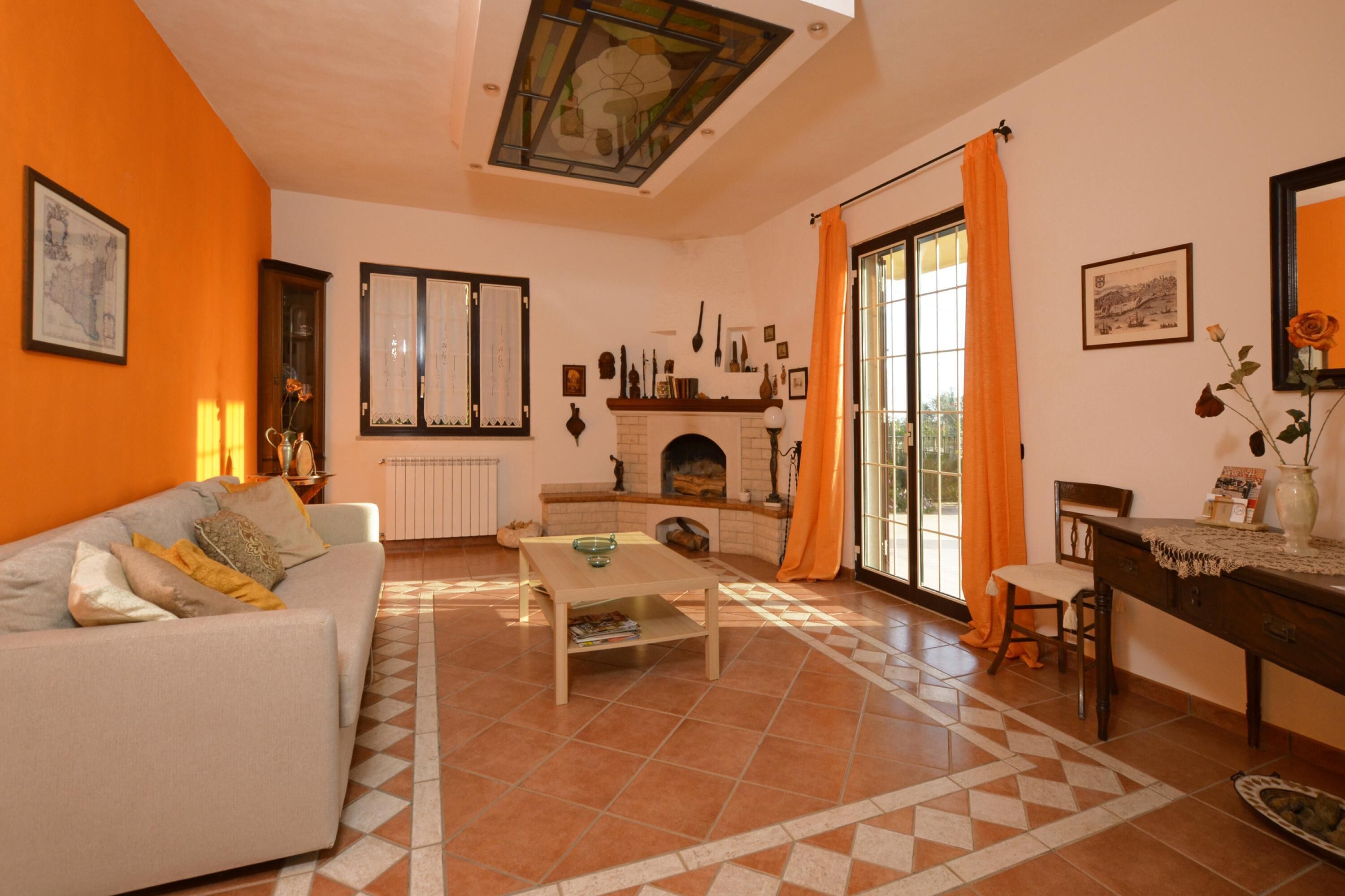 A living room with a sofa, a coffee table, a fireplace, and a dining area with a table and chairs.