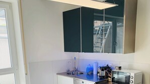 Una cocina moderna con una isla central, lavavajillas, microondas y fregadero.
