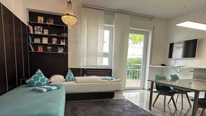 Un dormitorio moderno con cama, mesitas de noche, escritorio y televisor.