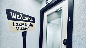 A welcome sign for Lakes Basin Village with a frosted glass door and a keypad lock.