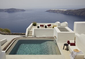 A rooftop pool with a view of the sea, white walls, and red and white furniture. - Atoles Retreat (Santorini)