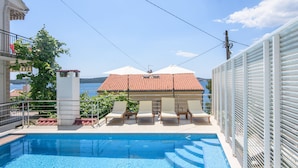 A swimming pool with lounge chairs and a view of the sea. - A3 90m2 apt W.shared Pool & Balcony,next to Beach (Trogir)