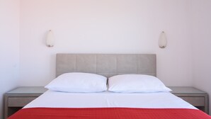 A bed with a grey headboard, two white pillows, and a red blanket. - A1-apt w. Shared Pool & Balcony,next to the Beach (Trogir)