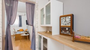 A room with a wooden counter, a clock, and a bed with pillows. - 2 - Modern Apartment With Garden, 80m From Beach (Marina)