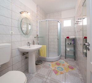 Departamento, varias camas | Baño | Regadera, amenidades de baño gratuitas, secadora de cabello, toallas 