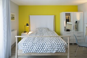 Cozy retreat with a bed, bedside table, and wardrobe, perfect for a restful stay.