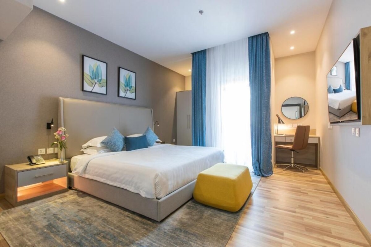 Une chambre moderne avec un lit, une table de chevet et un bureau avec une chaise.
