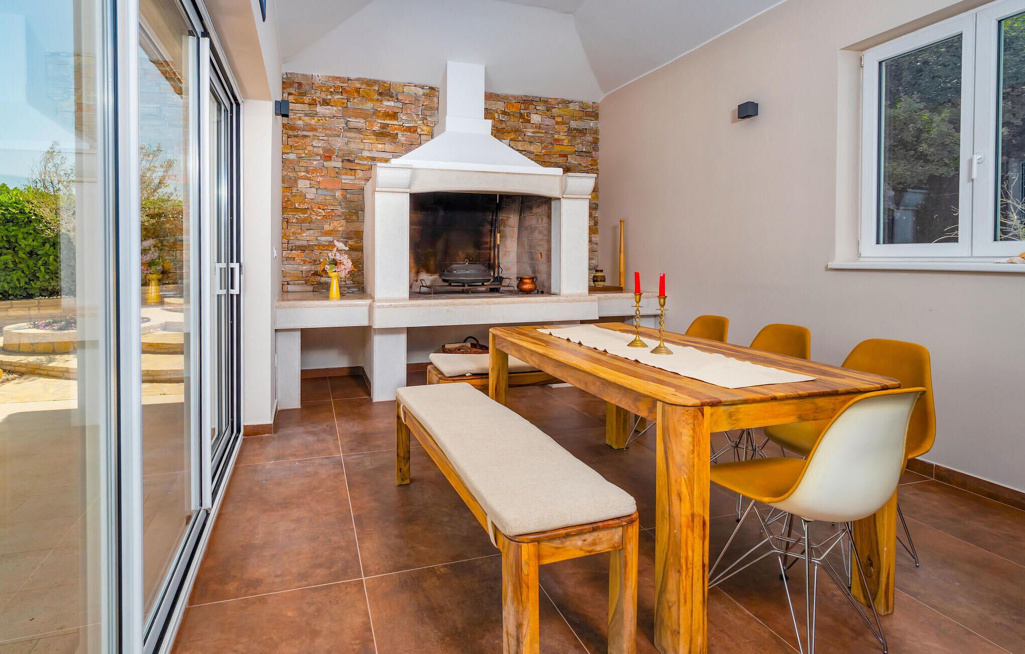 A dining area with a stone wall, a fireplace, and a table with chairs.