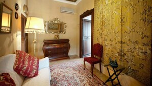 A room with a sofa, a red chair, a wooden cabinet, a lamp, and a patterned rug. - Son Sama (Llucmajor)