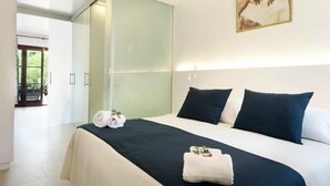 A hotel room with a large bed, two pillows, a bedside table, and a painting on the wall. - Son Sama (Llucmajor)