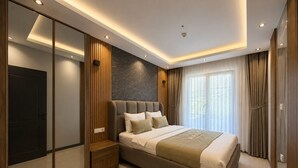 A modern bedroom with a large bed, built-in wardrobe, and a stone accent wall.