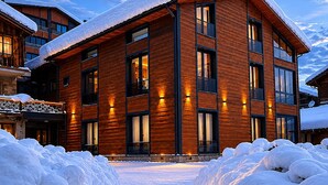 A multi-story building with a snow-covered roof and a stone foundation.