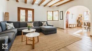 Ein modernes Wohnzimmer mit einem Ecksofa, zwei runden Couchtischen und einem großen Teppich.