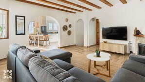 Ein modernes Wohnzimmer mit einer großen Couch, einem Fernseher und einem Kamin.