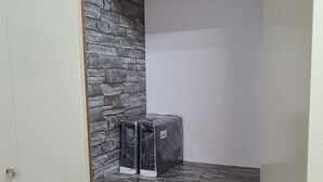 A wardrobe with a stone-patterned interior and a top shelf with folded items. - Magnifique Studio de 20m2 Pour 1 à 4 Personnes (Les Rousses)