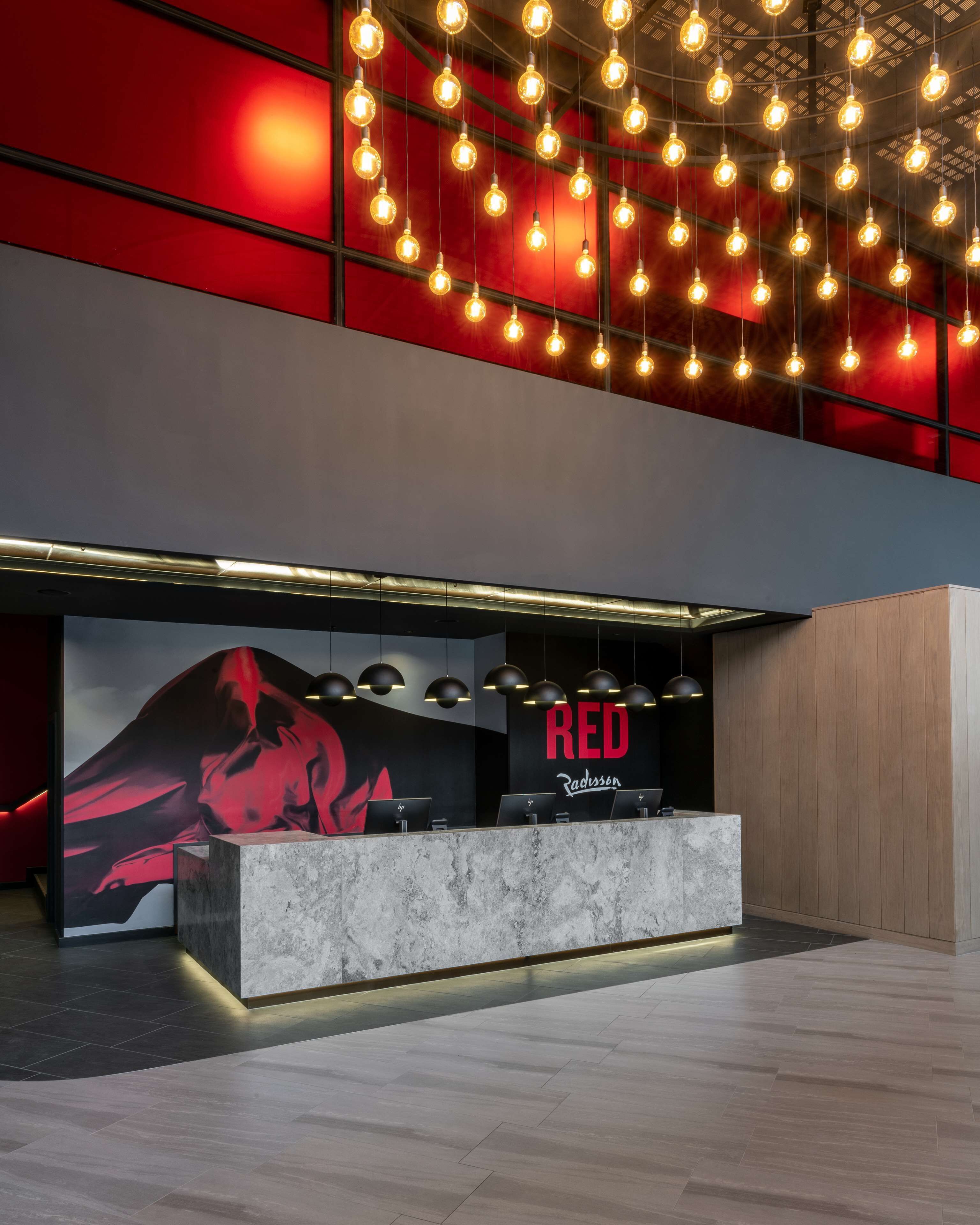 A modern reception desk with a marble top and a large red logo.