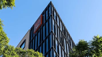Un edificio moderno con un llamativo letrero 'RED', rodeado de árboles.