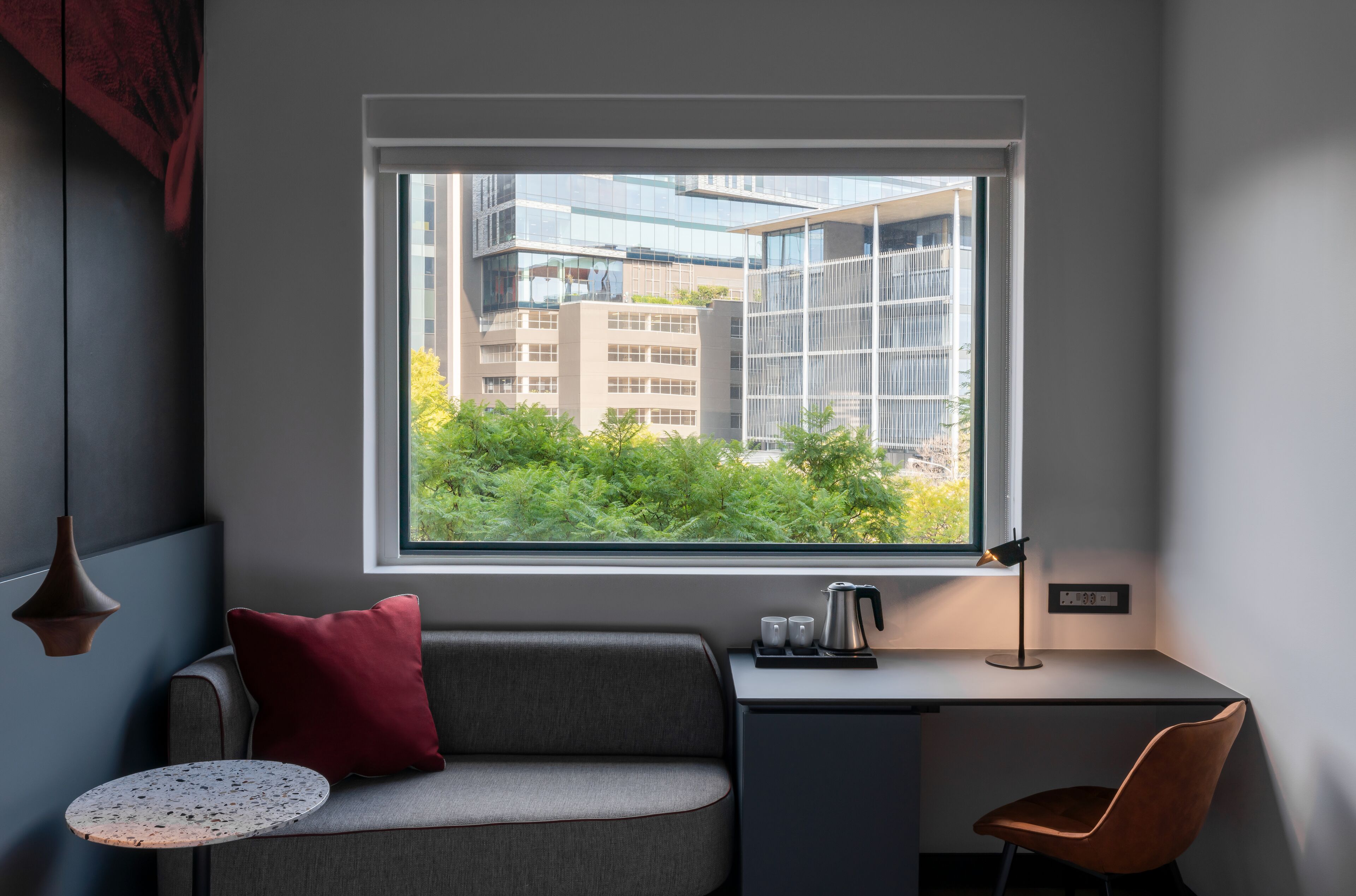 Una habitación moderna con un escritorio, una silla, un sofá y una mesita.