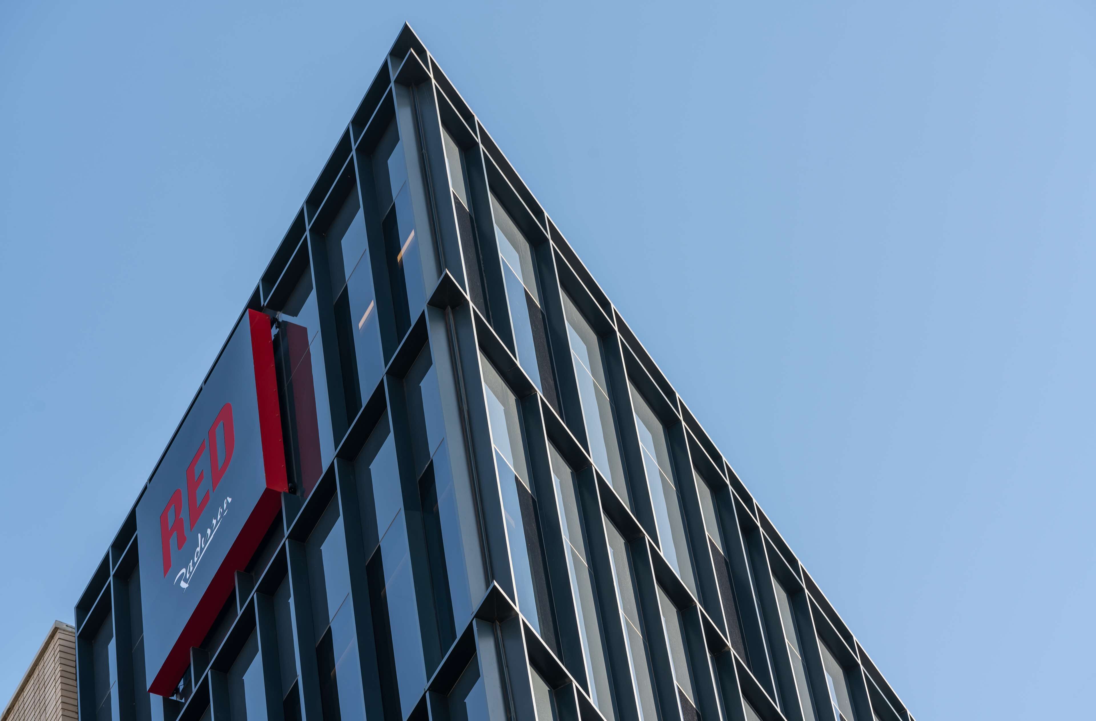 Un bâtiment moderne avec une grande enseigne « RED » bien visible sur le côté.