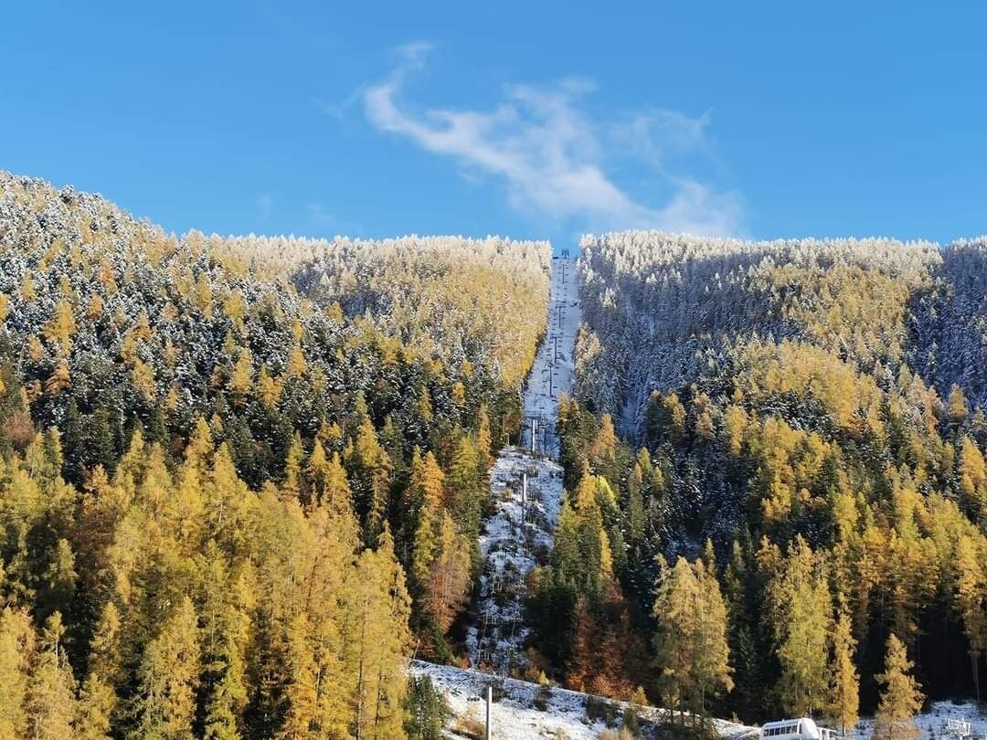 A mountain landscape with a ski lift and a cabin.