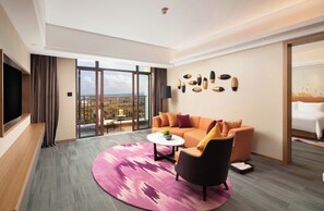 A modern hotel room with a large window, a sofa, a coffee table, and a TV. - Hampton BY Hilton Haikou Nanhai (HAIKOU)