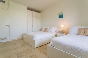 Una habitación de hotel con dos camas, un armario y un cuadro en la pared.