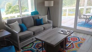 Un salon avec un canapé gris, une table basse et un tapis coloré.