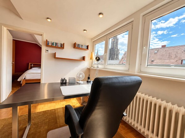 A modern room with a desk, chair, and bookshelves.
