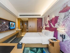A modern hotel room with a large bed, a desk, a flat-screen TV, and a wall-mounted phone. - Hampton BY Hilton Shiyan Yunyang (Shiyan)