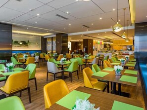 A restaurant with multiple tables and chairs, a bar area, and a large window with a view. - Hampton BY Hilton Shiyan Yunyang (Shiyan)