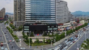Een modern hotel met een gebogen gevel, meerdere verdiepingen en opvallend bewegwijzeringsmateriaal.