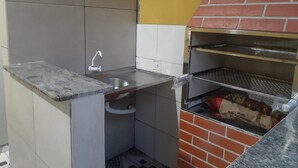 Una cocina compacta con un fregadero, una pequeña encimera y un horno empotrado.
