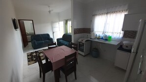 Un espacio habitable compacto con kitchenette, comedor y sofá.