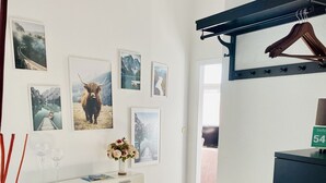 Une chambre moderne avec une commode blanche, un meuble noir et un tapis gris.