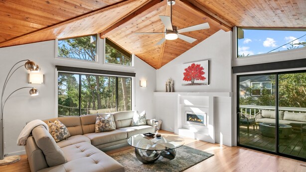 Una sala moderna con un sofá modular, una mesa de centro de vidrio y una chimenea.