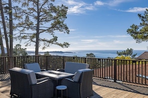 A deck with outdoor furniture, a view of the ocean, and a wooden railing. - Pacific Panorama: Stunning Ocean Views and Pacific Sunsets (Carmel)