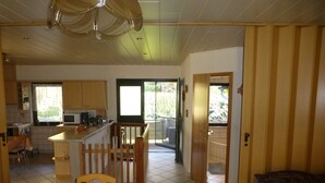 A spacious kitchen with a dining area, a small island, and a view of the outdoors. - Vacation apartment Burgblick 2 (Großlohra)