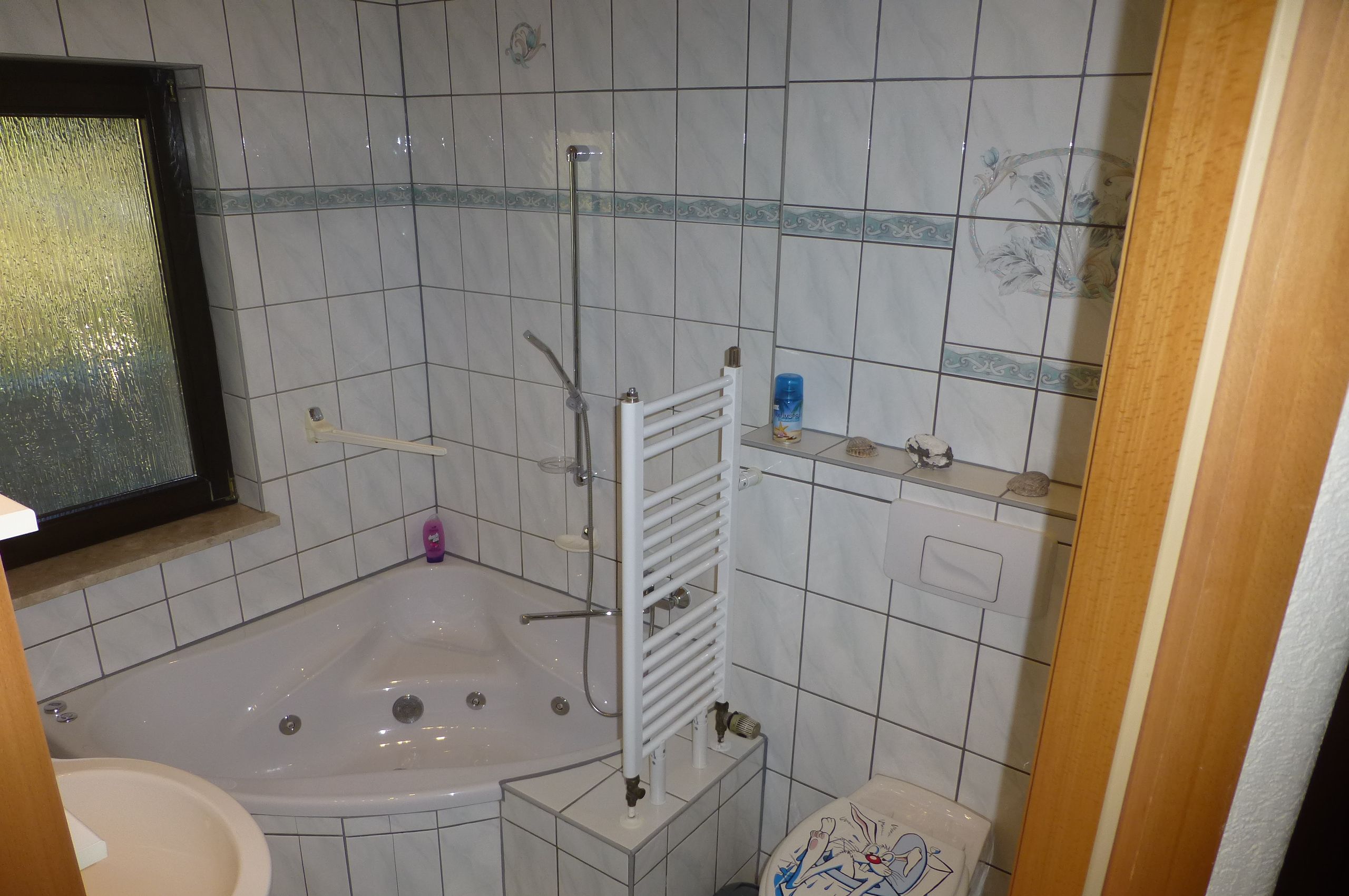 Een badkamer met een bad, toilet en een douchehoek.