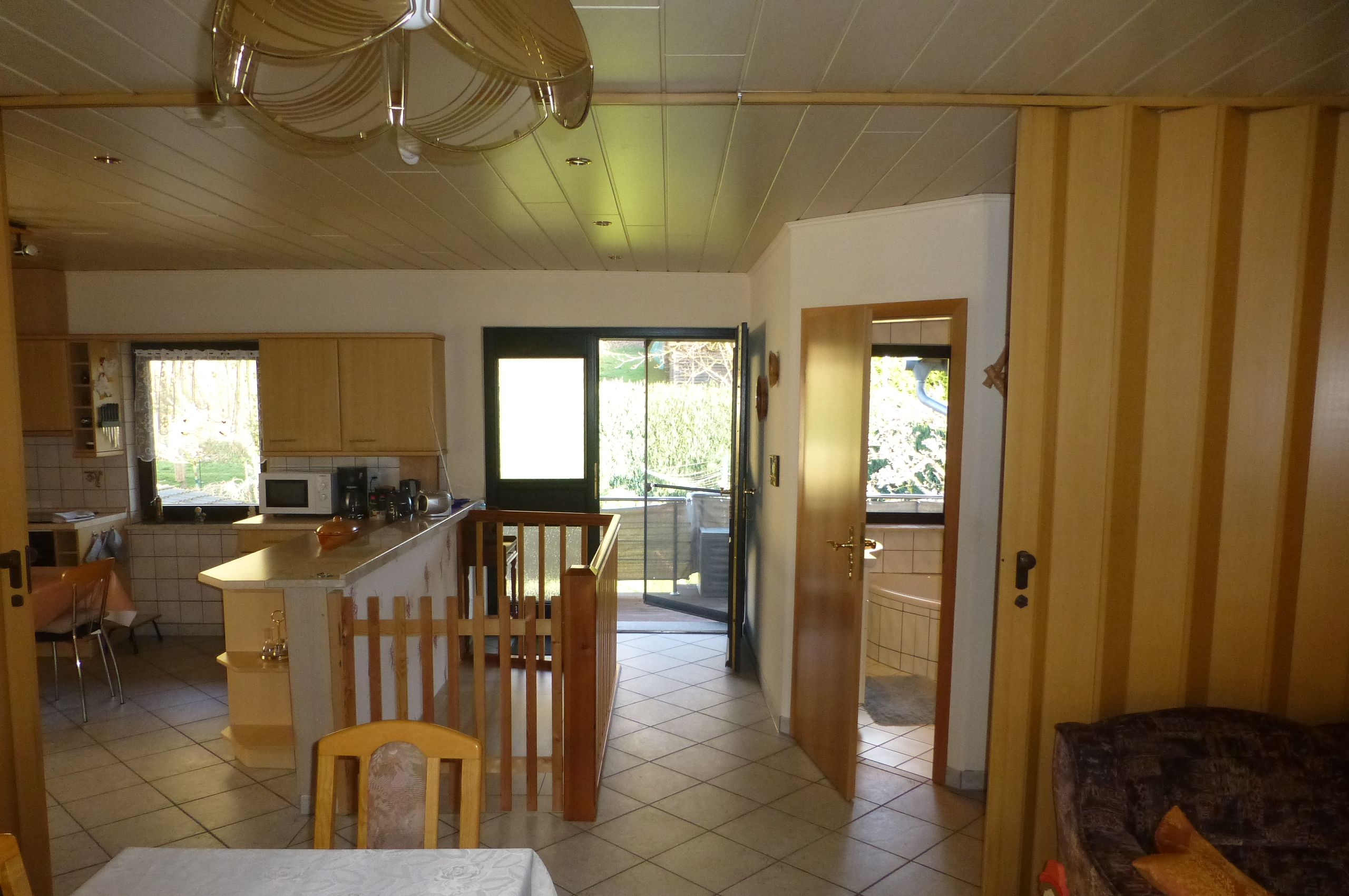Una cocina amplia con comedor, una pequeña isla y vistas al exterior.