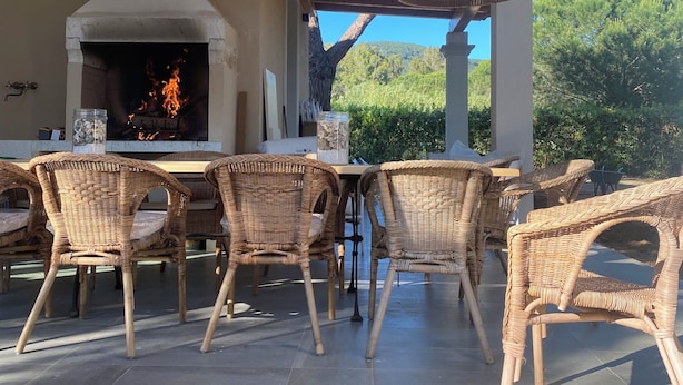 An outdoor patio with wicker furniture, a stone-tiled floor, and a wood-beamed ceiling. - Casa Riservata Immersa Nella Natura con Spiaggia Raggiungibile a Piedi (Toscana)