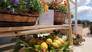 Wicker baskets filled with flowers and lemons on a wooden table.