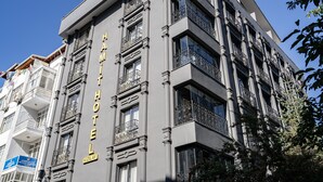 A multi-story hotel with a classic architectural design, featuring balconies with wrought iron railings and a prominent sign indicating its name and location. - Hamit Hotel Kizilay (Ankara)