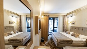 A hotel room with two beds, a mirror, a small table with a plate of cookies, and a view of the outside through a door. - Hamit Hotel Kizilay (Ankara)