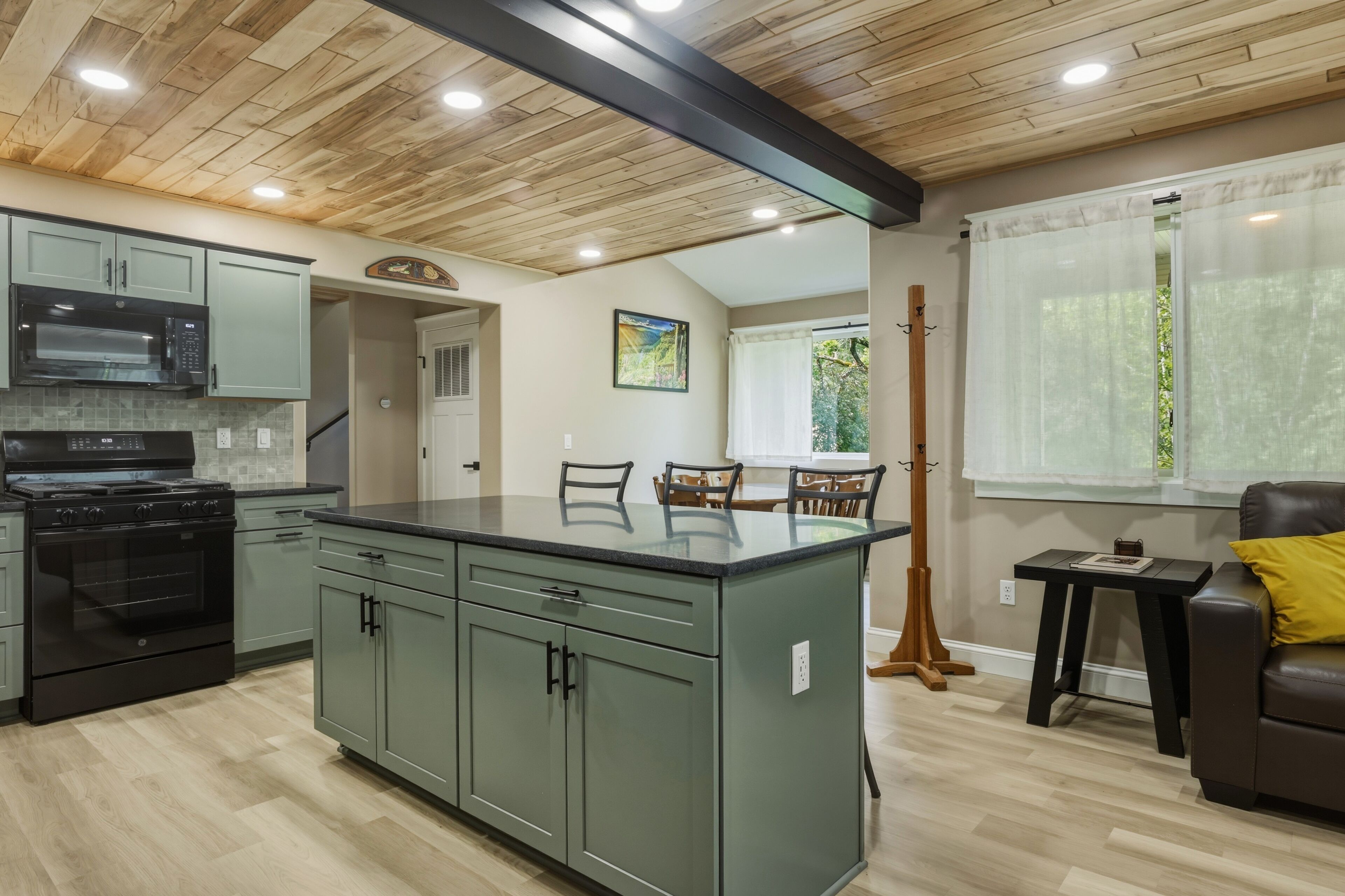 Une cuisine dotée d’un îlot central, d’appareils électroménagers intégrés et d’un coin repas avec des chaises.