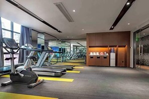A modern gym with treadmills, a stationary bike, and weight machines.
