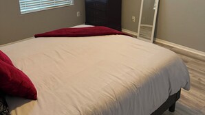 A bedroom with a bed, a dresser, a mirror, and artwork on the wall. - Sheppard 3bd1ba FtHuaSierraVista baby-massage (Sierra Vista)