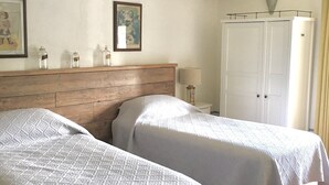 A bedroom with two beds, a wooden headboard, a white wardrobe, and a tiled floor. - Spectacular views from this villa for 8 in Valdorcia. Private Pool. (Sarteano)